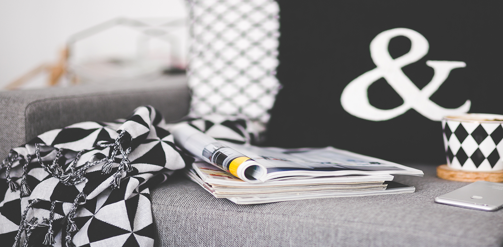 Close-of-magazines-mug-and-phone-on-a-couch